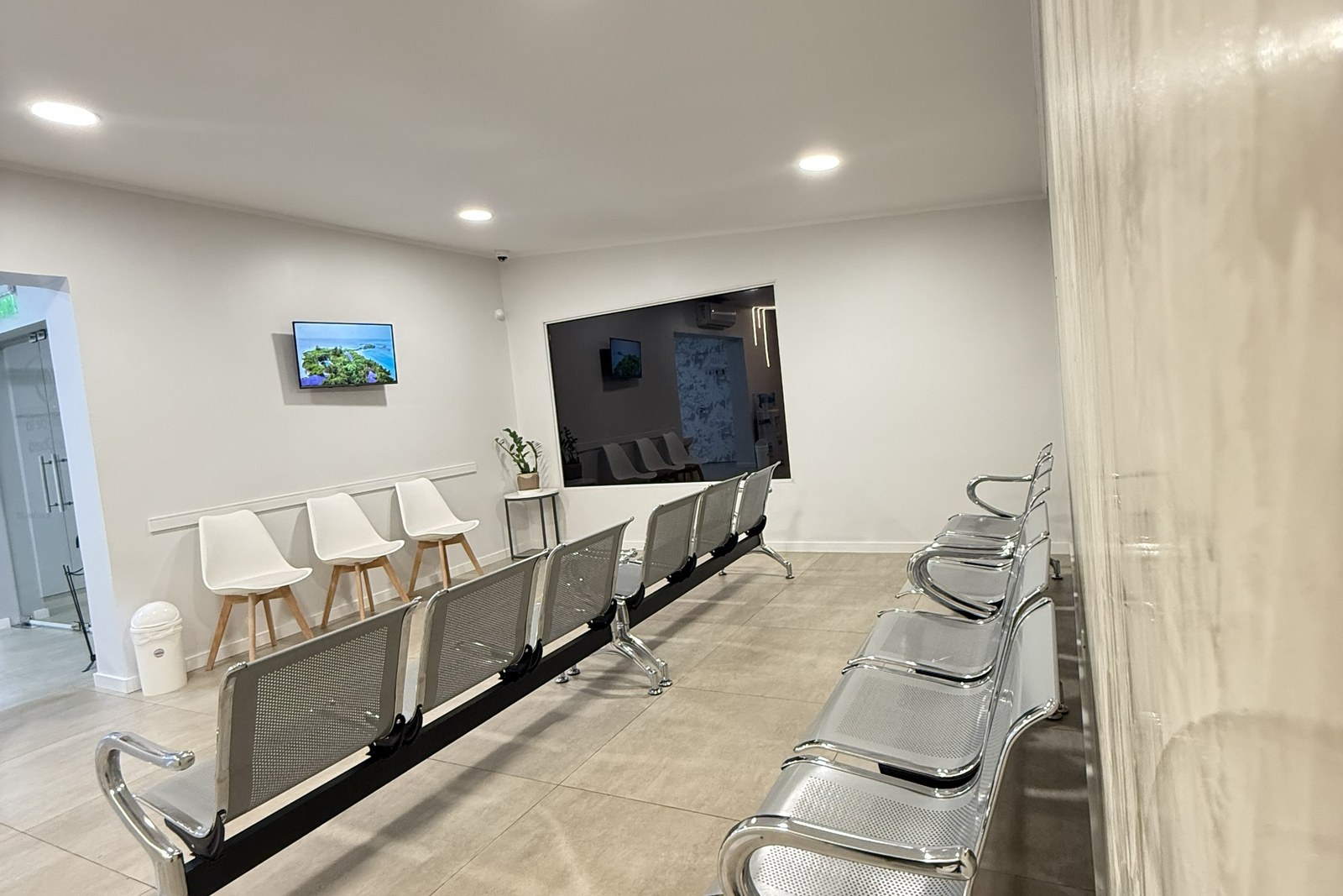 Sala de espera del Centro de la Visión con butacas, televisor y la ventanilla de recepción a la vista