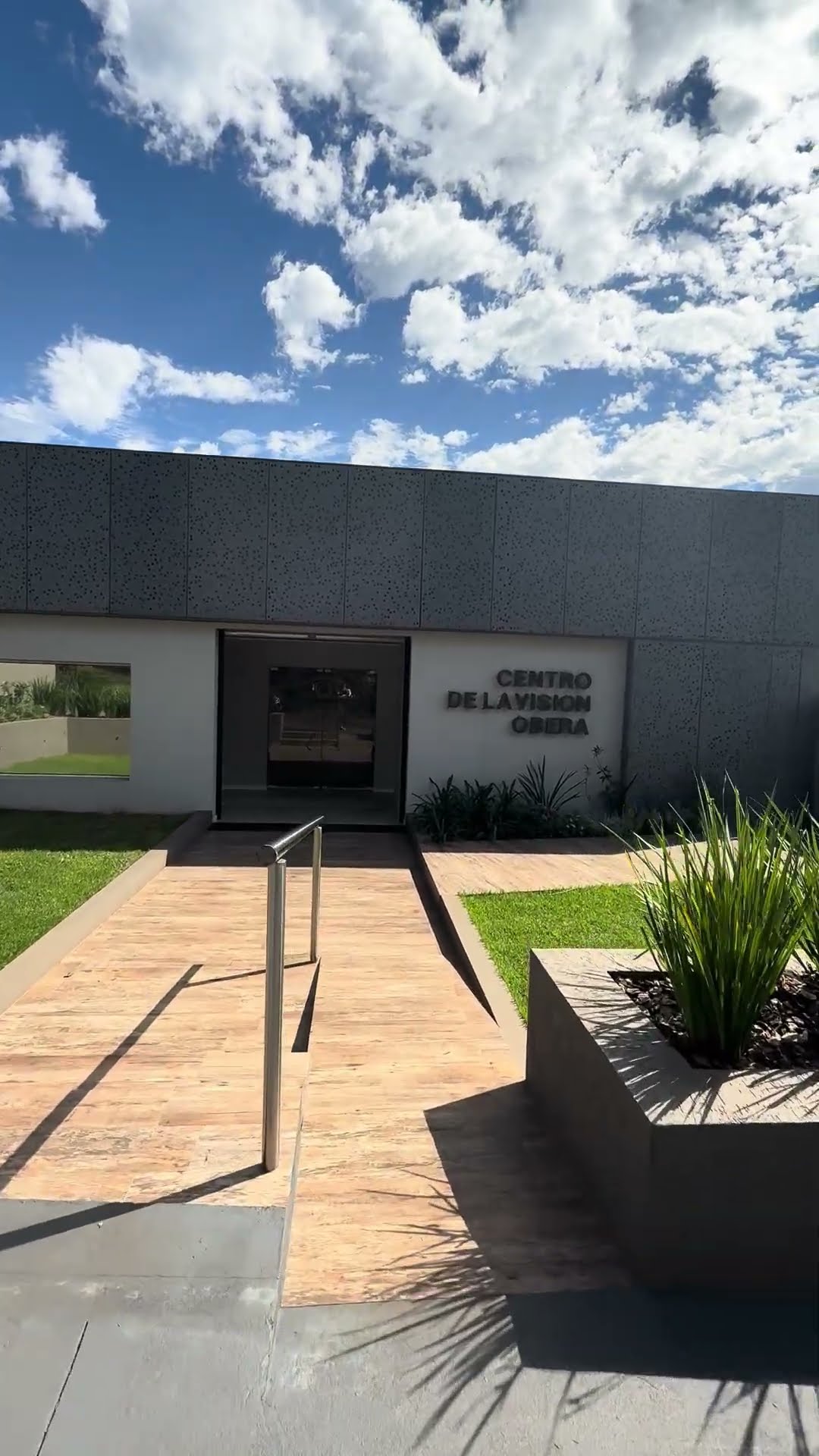 Rampa de acceso con pasamanos hacia la puerta del Centro de la Visión